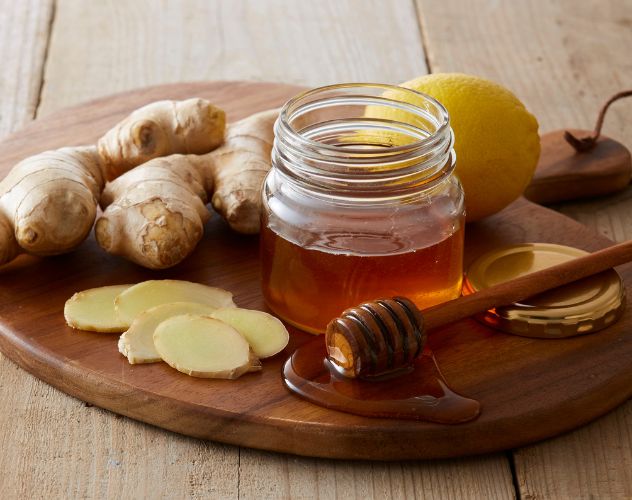 honey lemon and ginger ingredients on a wooden board