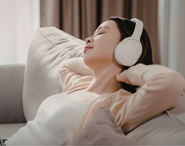 woman relaxing on sofa with headphones on